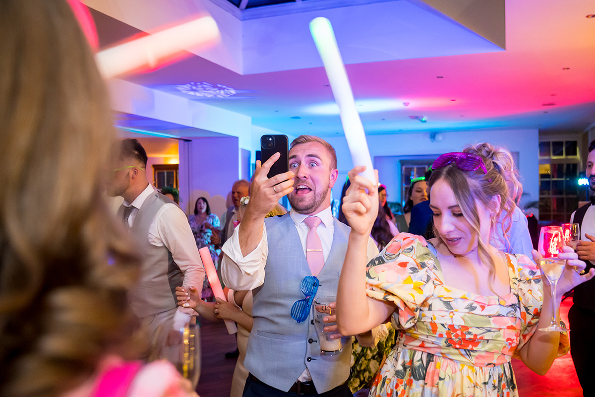 Guests dancing at vibrant indoor party with drinks.