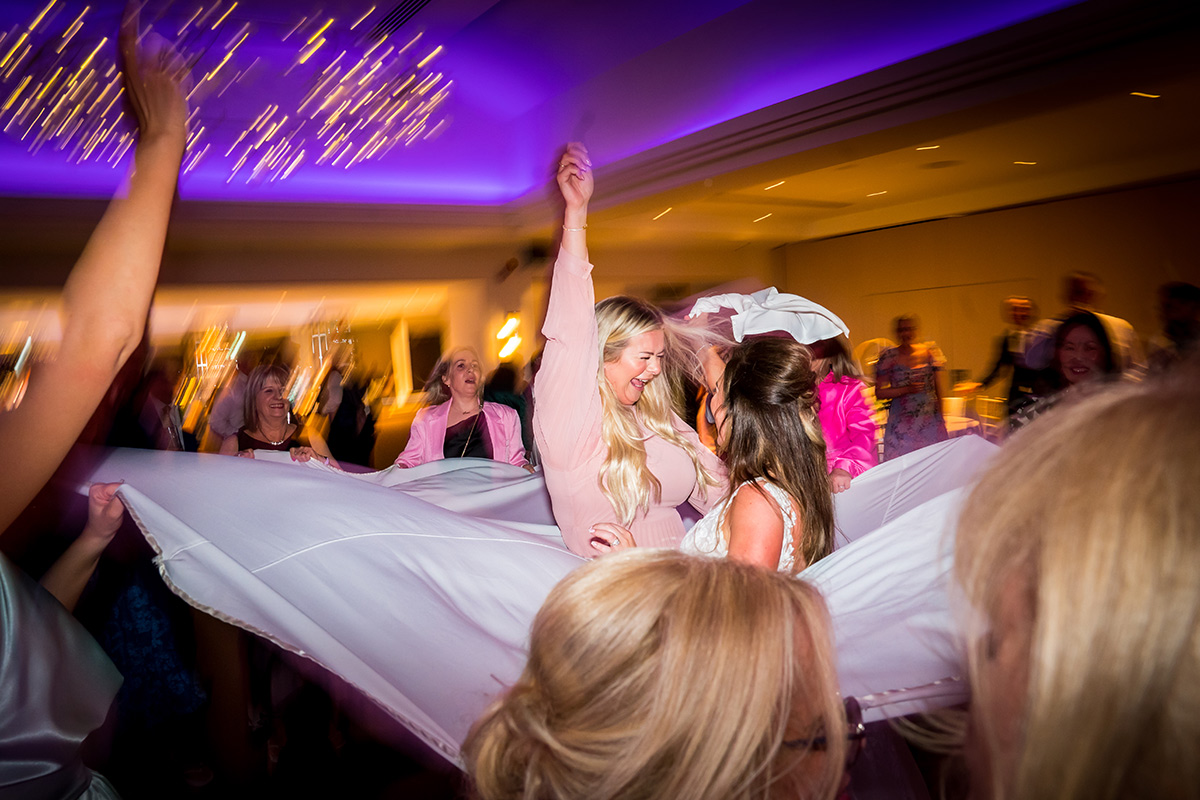 Group dancing joyfully under purple lights