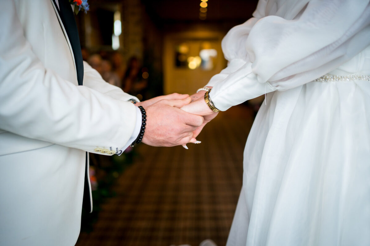 Couple holding hands at a wedding ceremony.