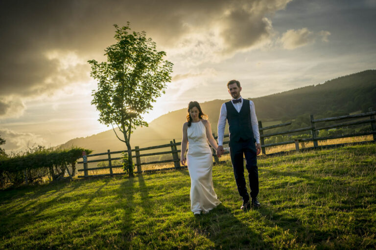 Couple holding hands, walking at sunset