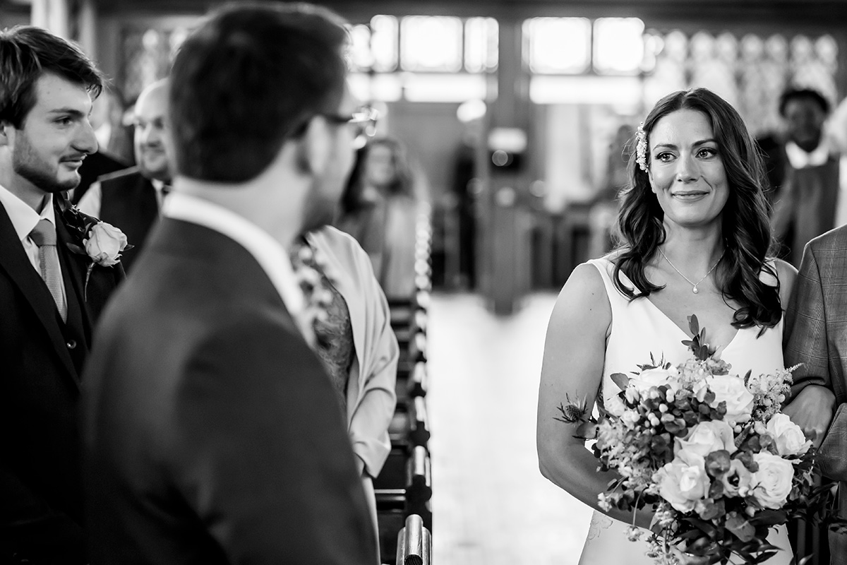 Bride and groom exchanging heartfelt glances in church.