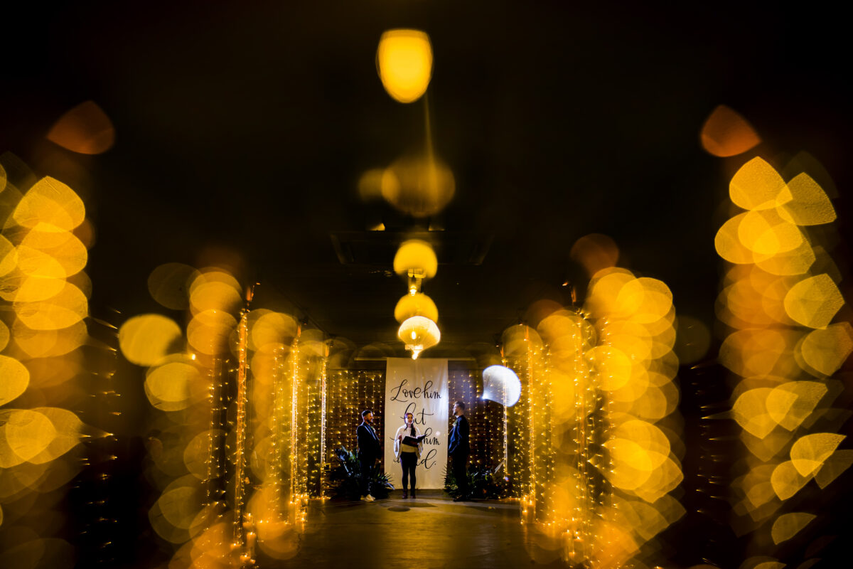 Dimly lit wedding ceremony with golden lights.
