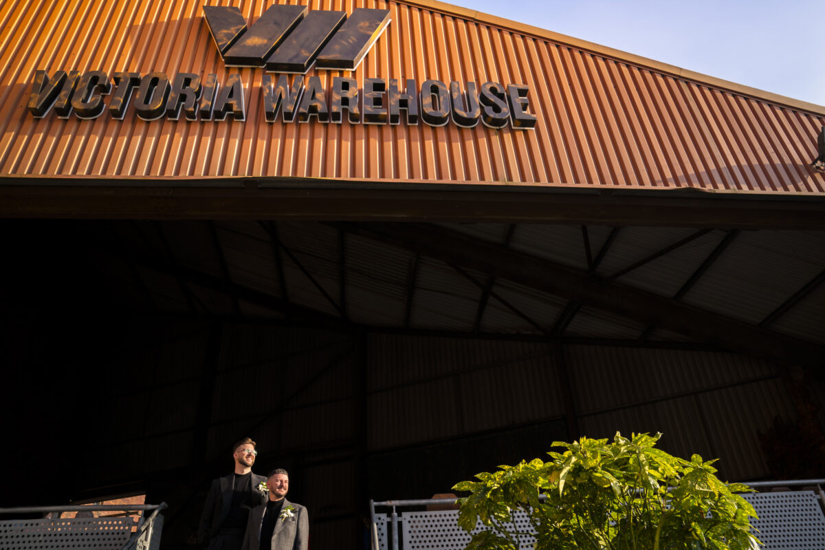 Two men standing outside Victoria Warehouse.