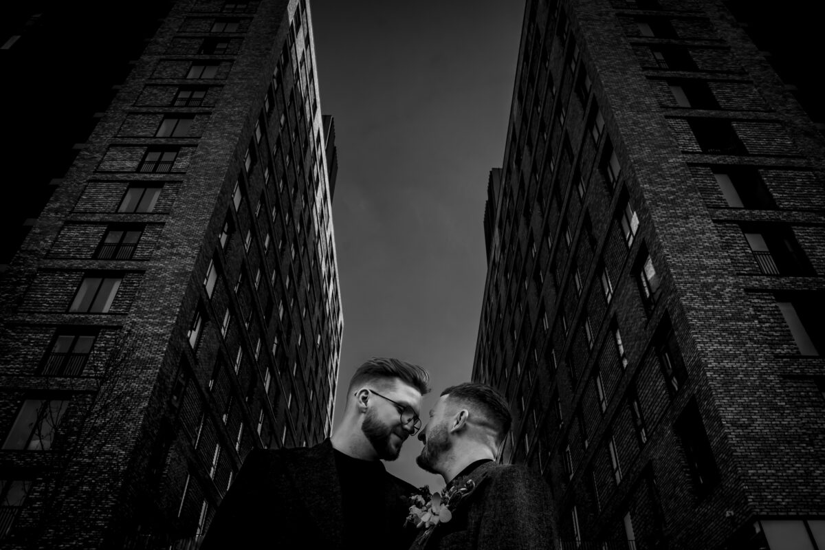 Couple embracing between tall buildings
