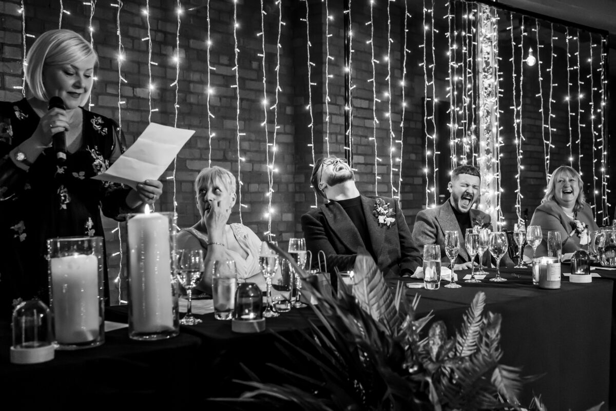 Woman giving a speech at wedding reception.