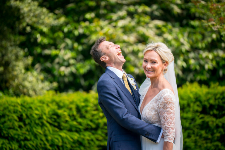 Smiling couple in wedding attire in garden
