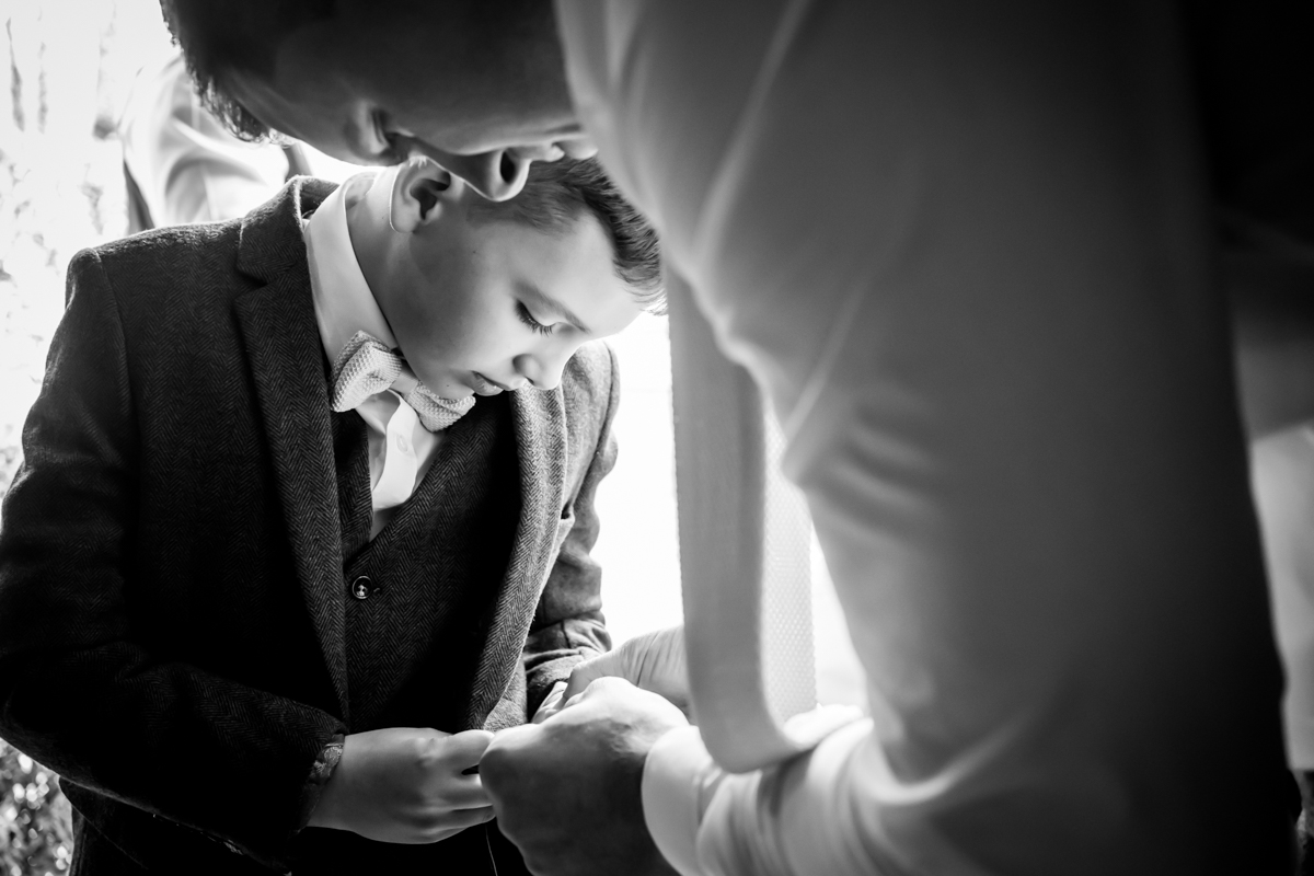 Young boy preparing for wedding ceremony, black and white