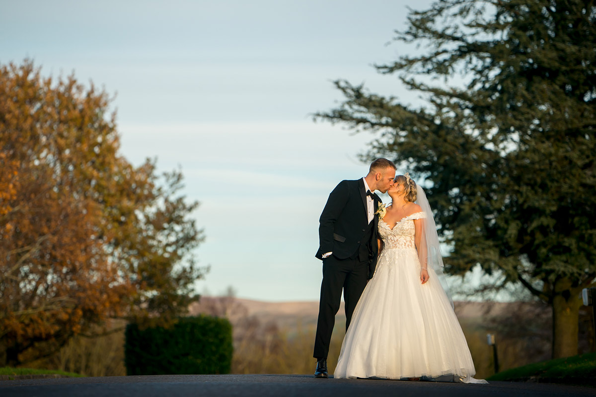 Bride and groom kissing outdoors