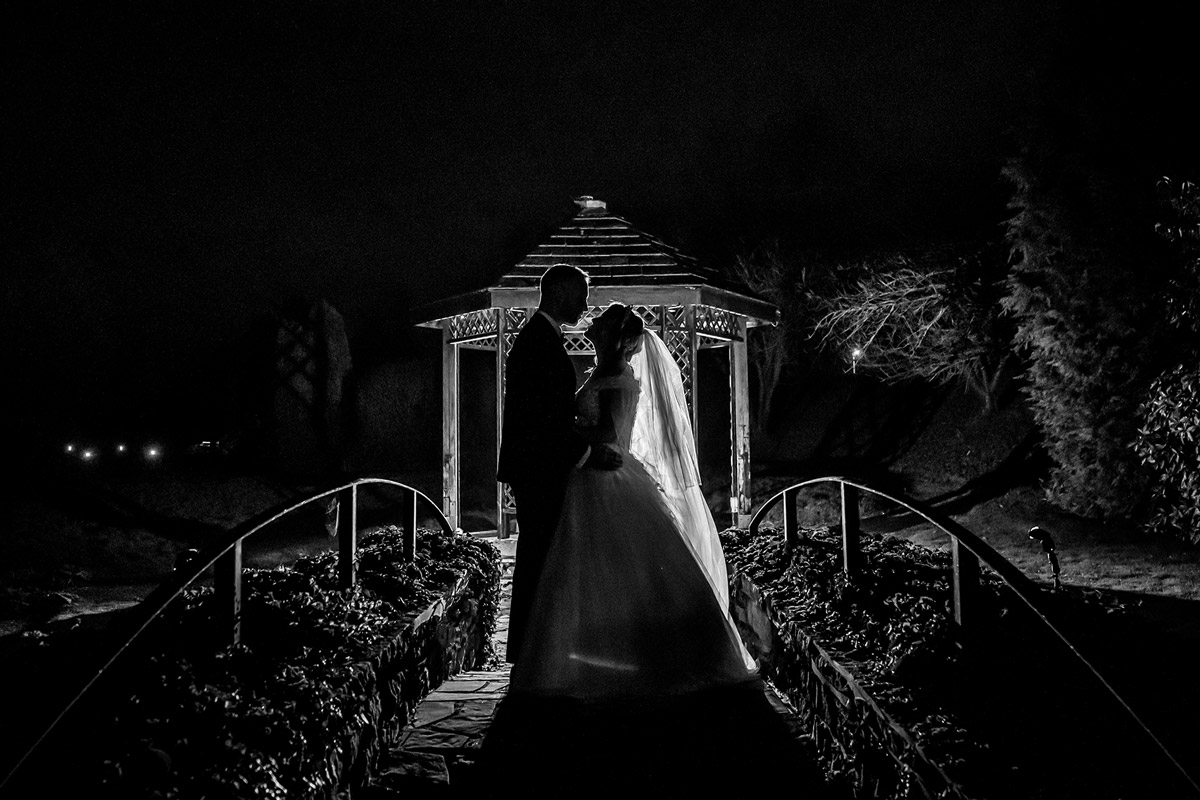 Silhouette of couple under gazebo at night