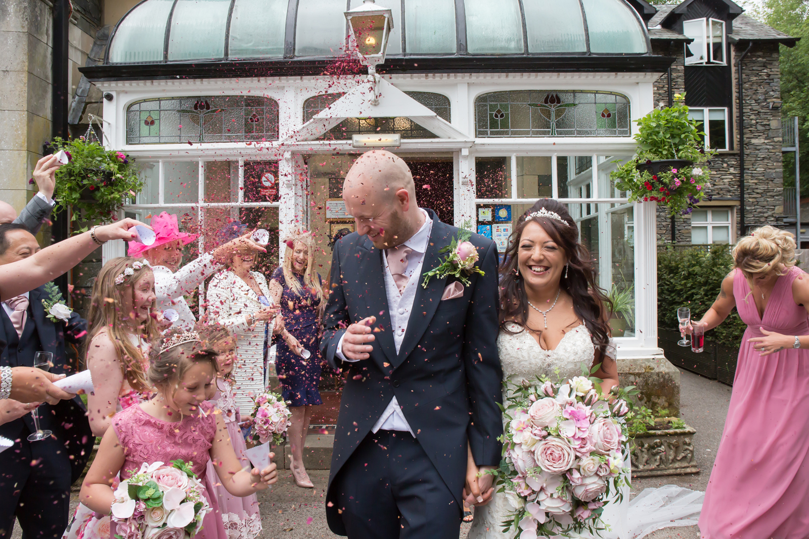 Wedding couple showered with confetti outside venue.