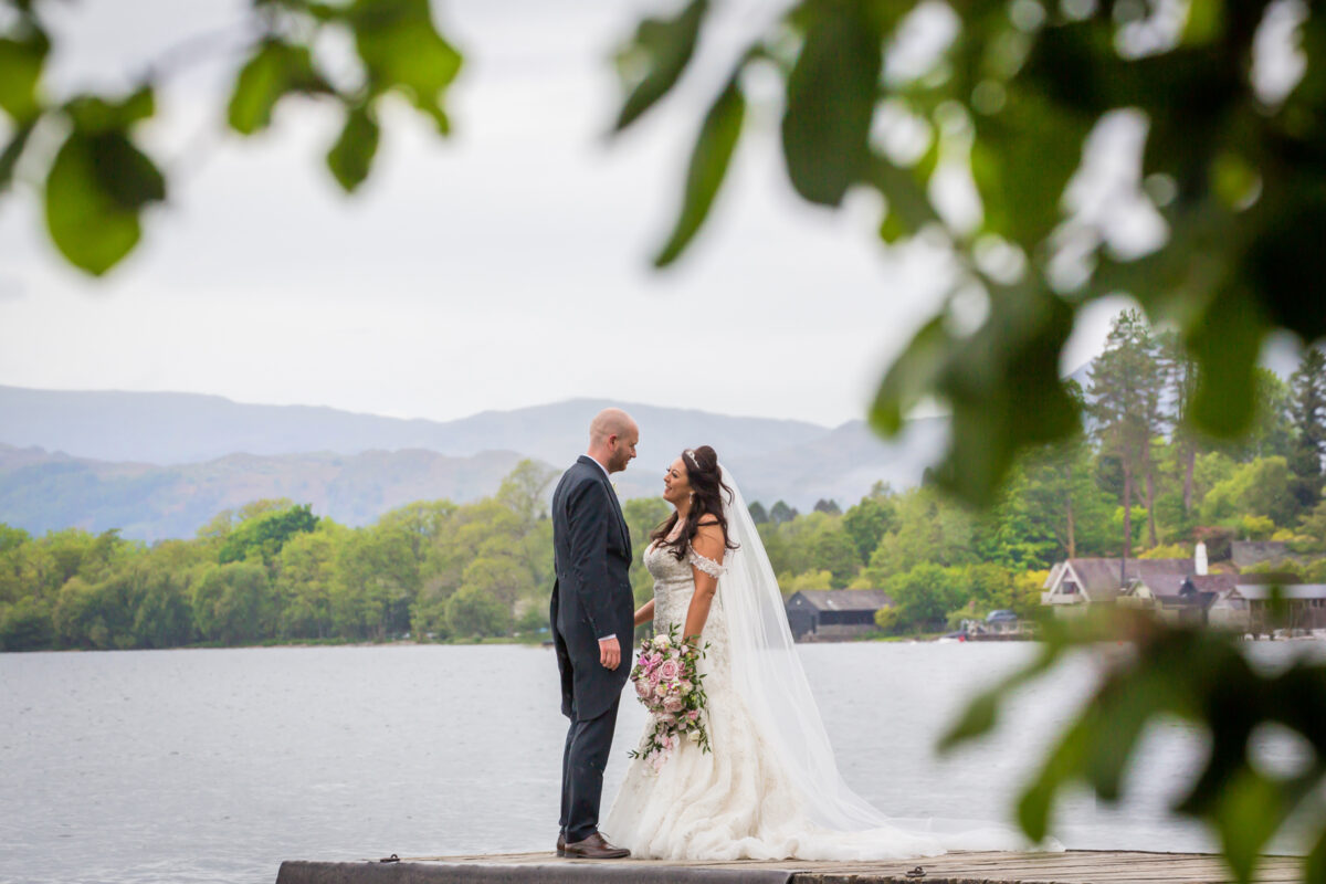 Bride and groom on lakeside dock.