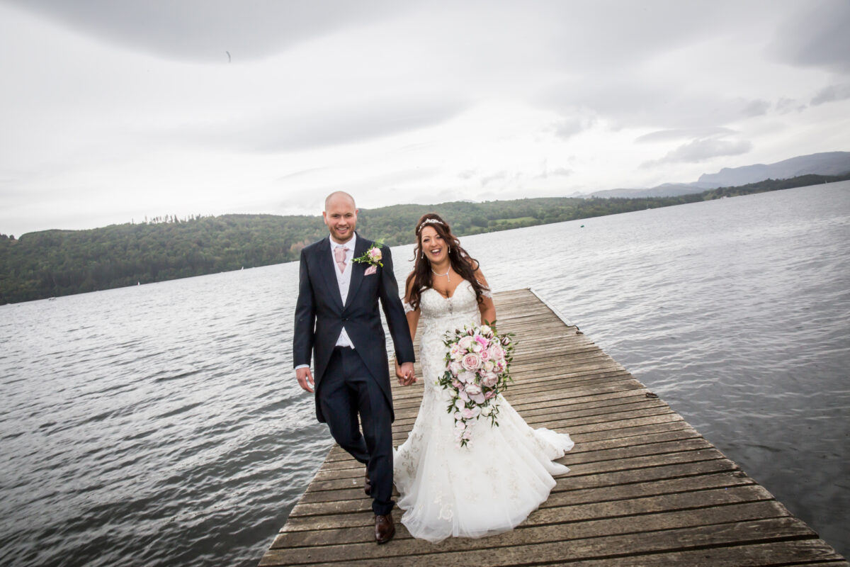 Smiling couple on a lakeside wedding dock.