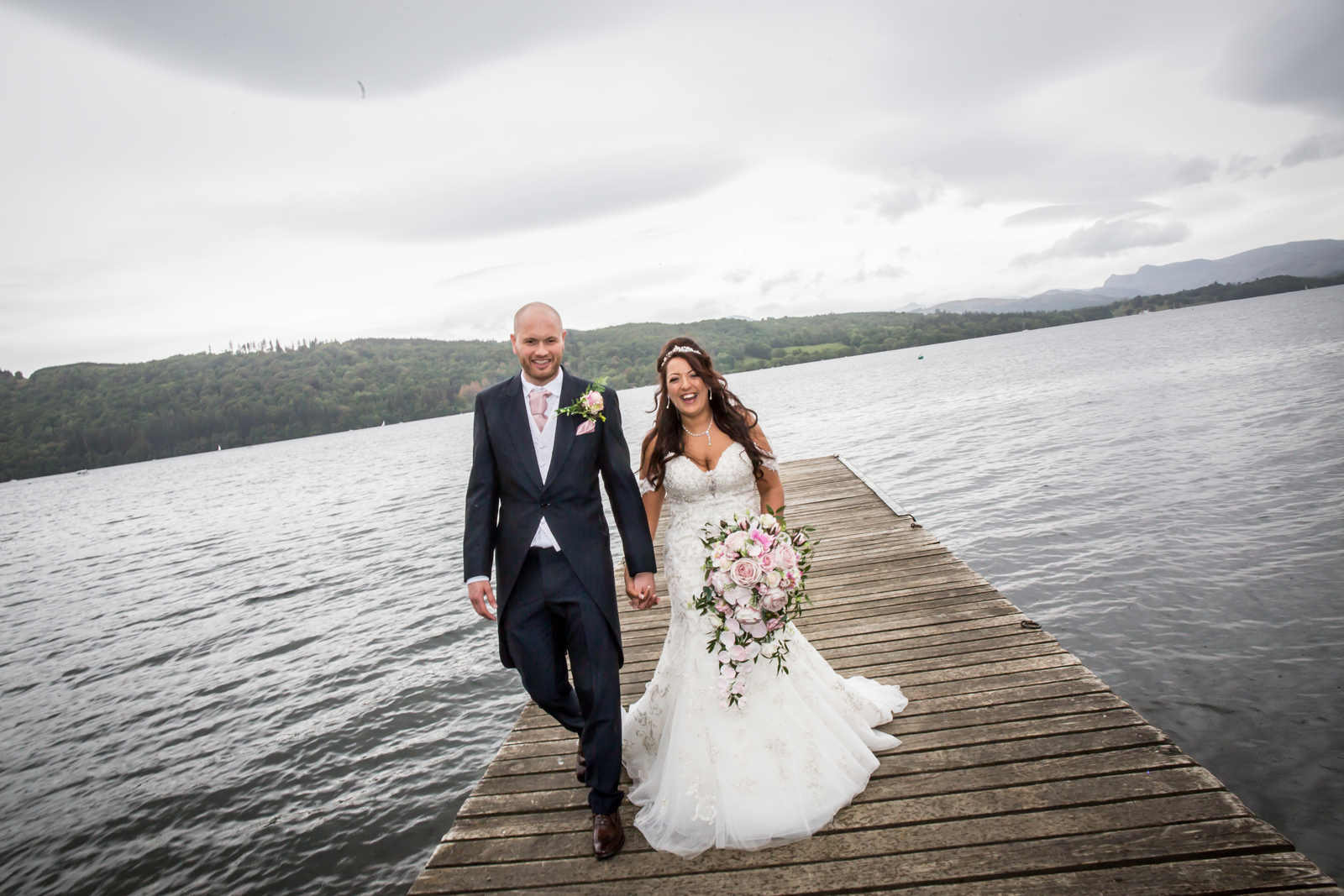 Smiling couple on a lakeside wedding dock.