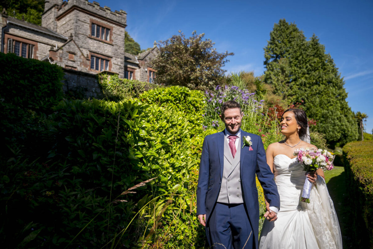 Bride and groom outside rustic building, smiling.