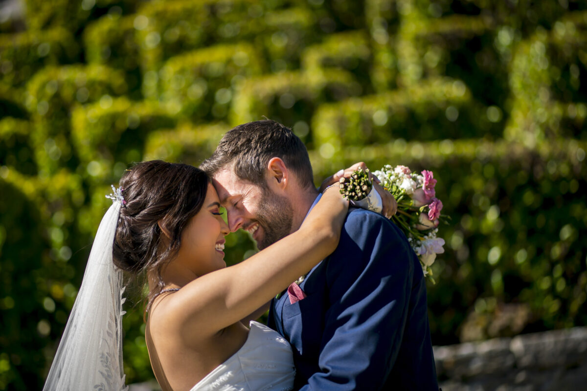 Bride and groom embracing in garden wedding
