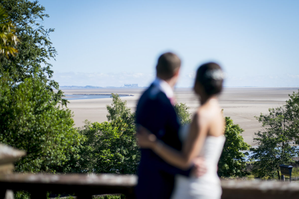 Couple overlooking scenic beach landscape, sunny day view.