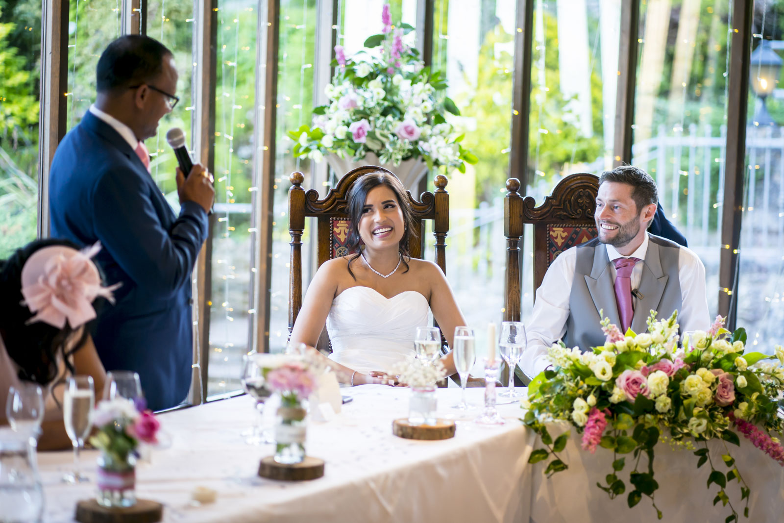 Wedding couple smiling during reception speech
