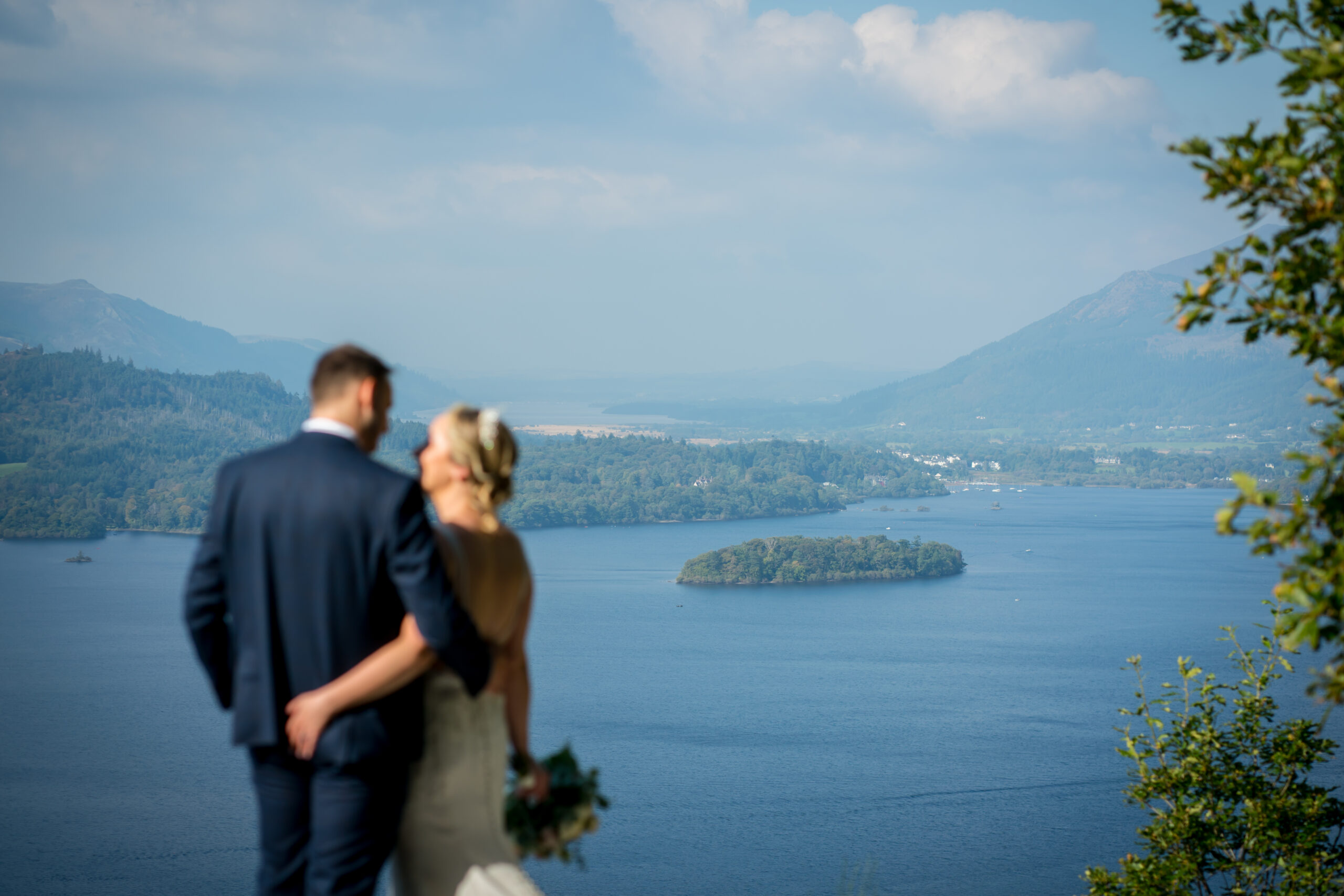 Couple overlooking lake and mountains on wedding day.