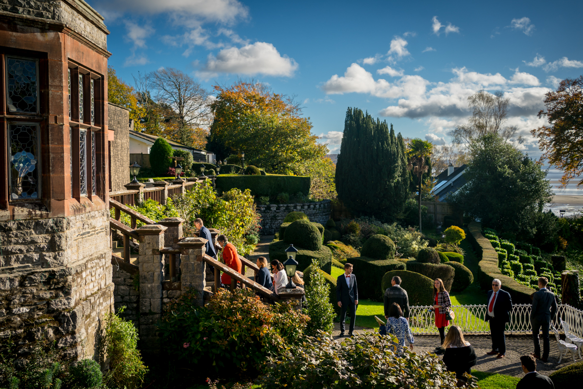 People walking in a picturesque garden under blue sky.