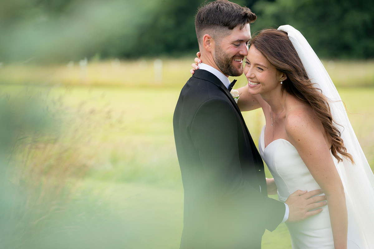 Happy couple embracing outdoors on wedding day