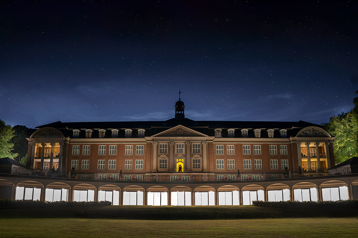 Illuminated building under starry night sky.