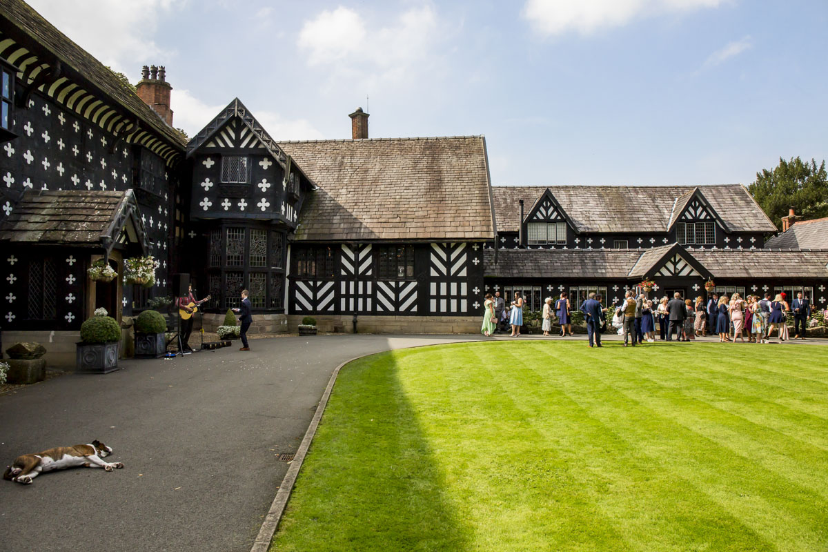 Tudor-style house with group gathered outside on lawn.