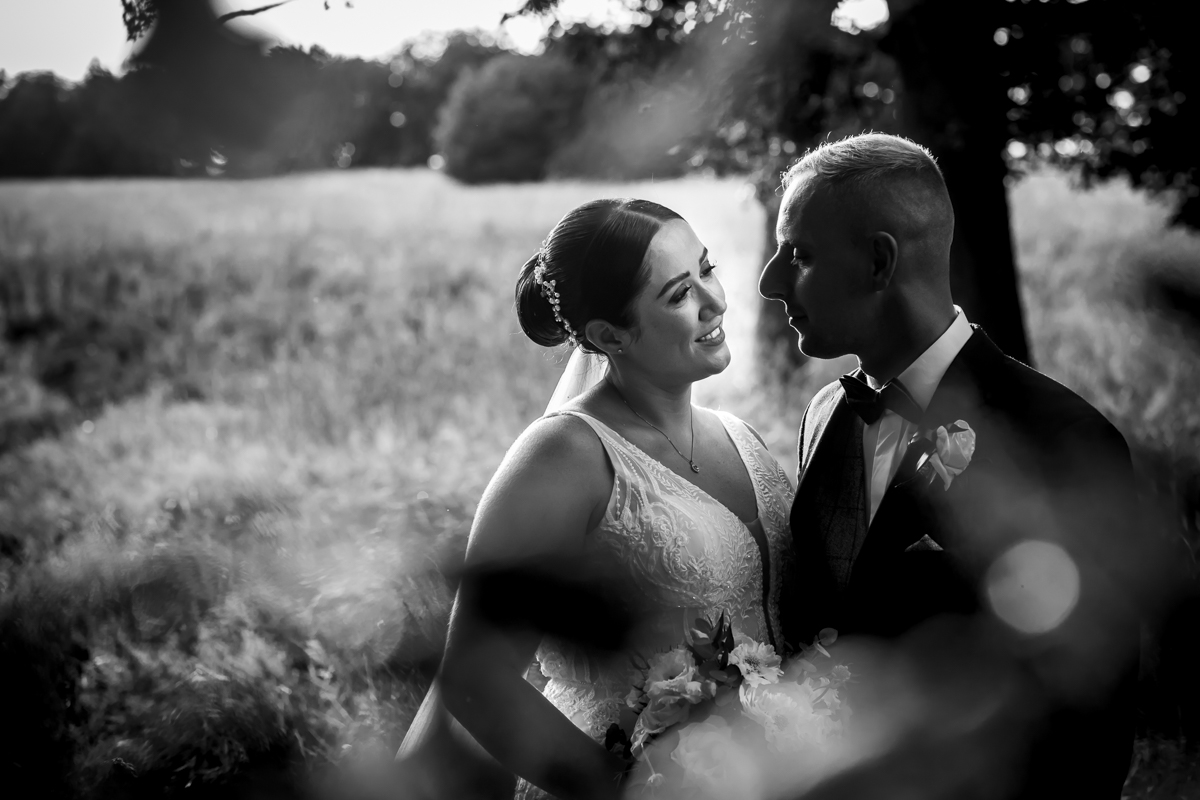 Black and white romantic wedding couple embrace outdoors.