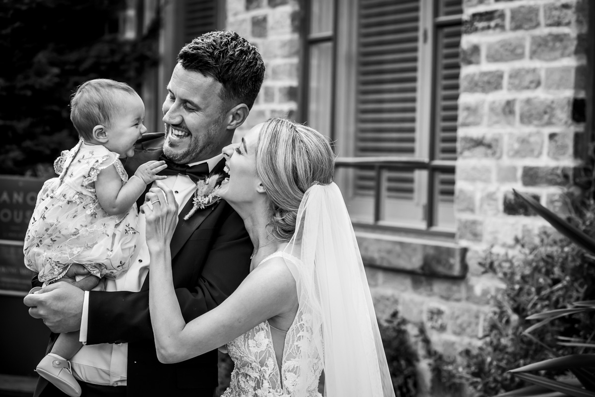 Family smiling happily on wedding day.