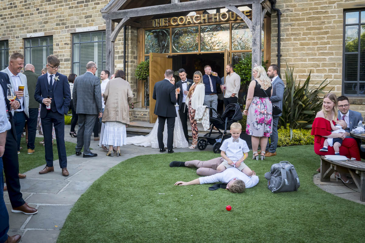 Wedding guests socialising outside Coach House venue.
