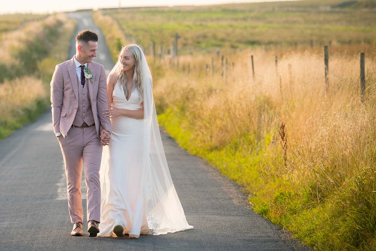 Couple walking down rural road at sunset