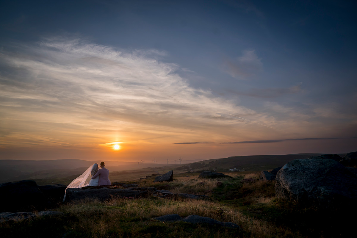 Couple watching sunset on a hilltop
