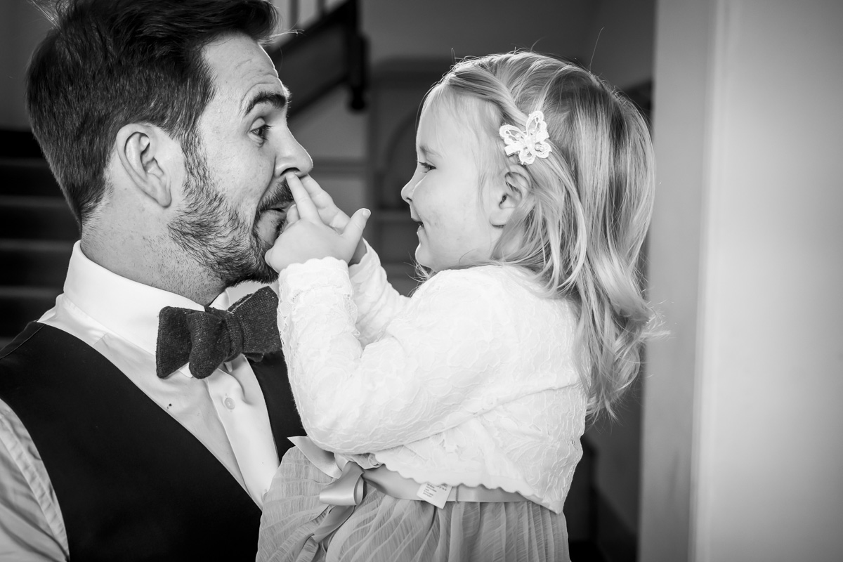 Man with daughter playfully touching his nose.