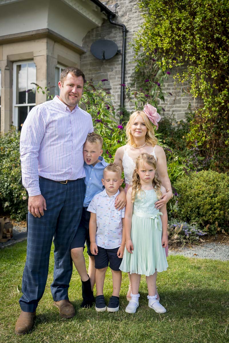 Family posing outdoors in formal attire.