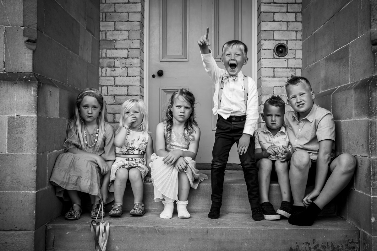 Black-and-white photo of six children on steps.