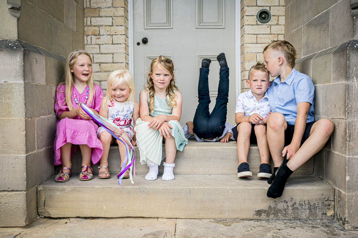 Children sitting on steps, one upside down.