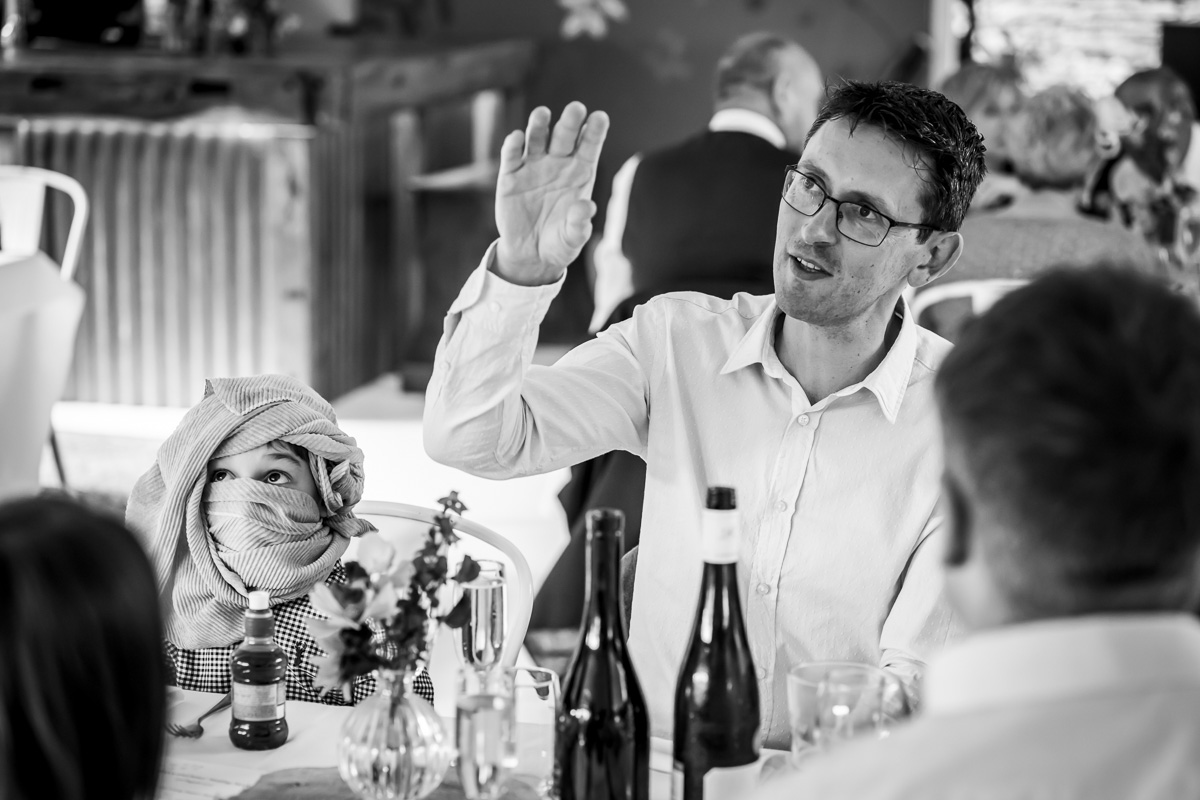 Man and child talking at a table gathering.