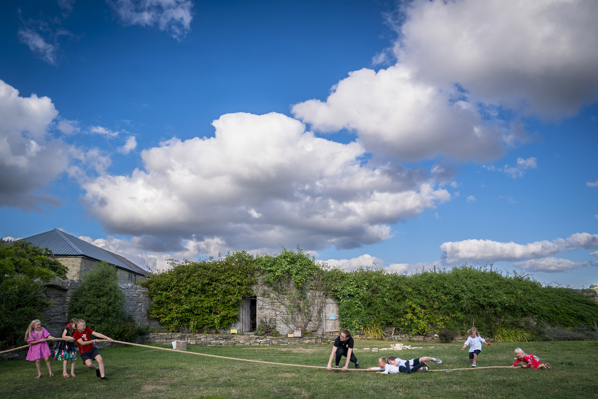Children playing tug of war in garden.