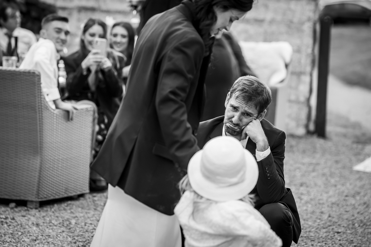 Man kneeling, child and people watching at event.