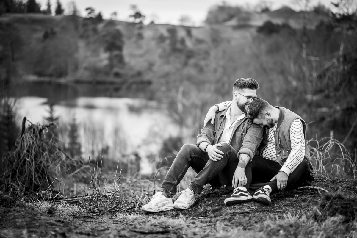 Couple sitting together in nature, black and white photo.