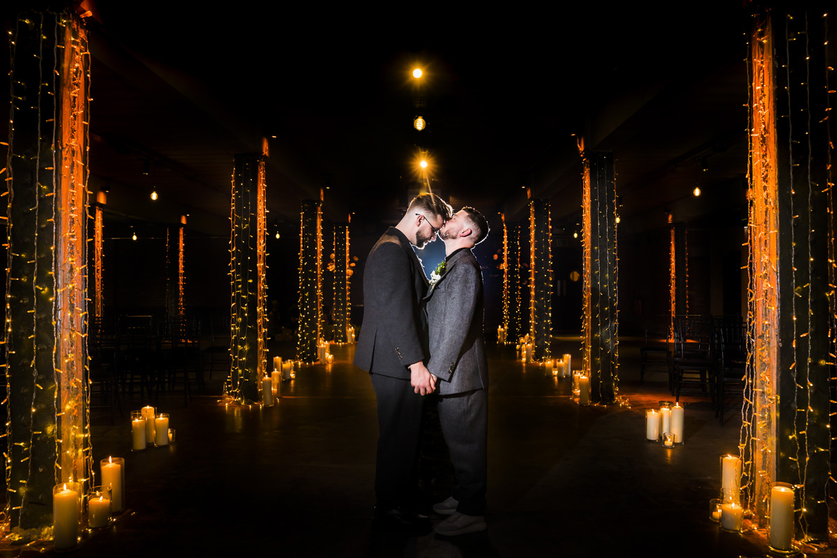 Couple kissing in a candle-lit venue with fairy lights.