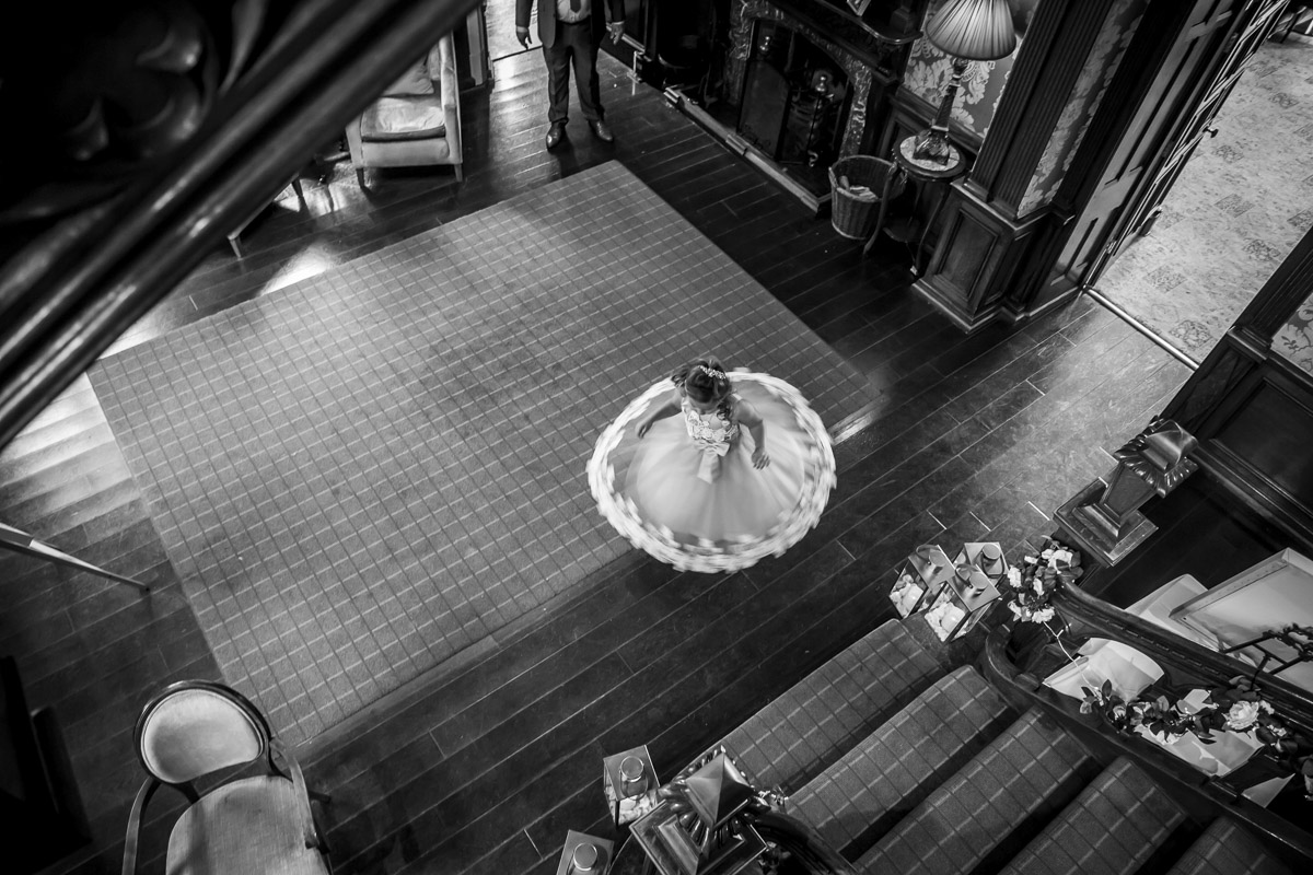 Girl twirling in elegant dress on wooden floor.