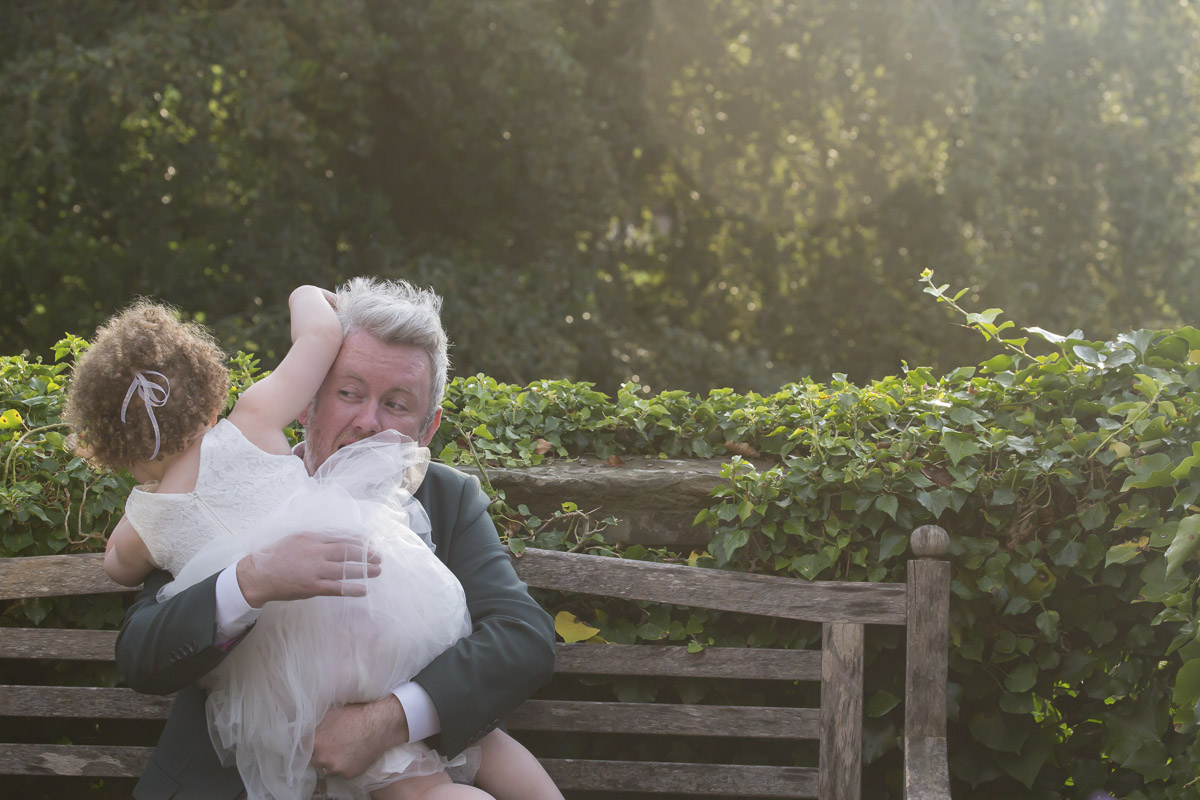 Man holding child on park bench outdoors