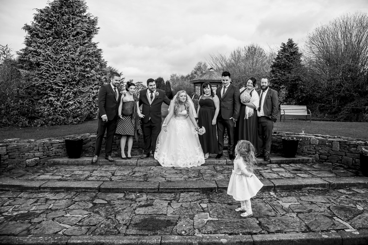 Wedding party with bride, group pose outdoors.