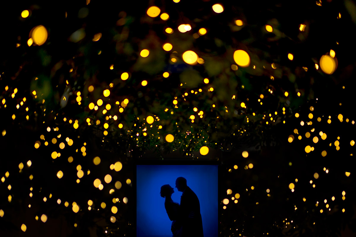 Romantic silhouette under glowing festive lights.