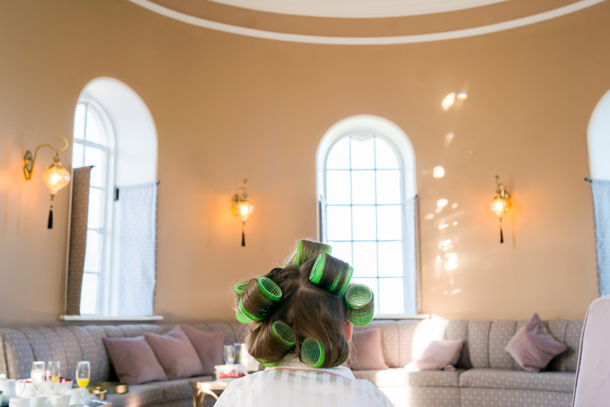 Woman with curlers relaxing in sunny lounge.