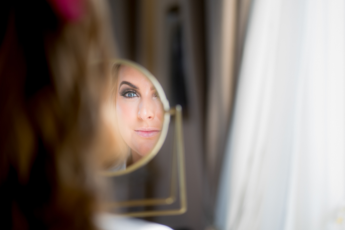 Woman's reflection in a mirror, close-up view.