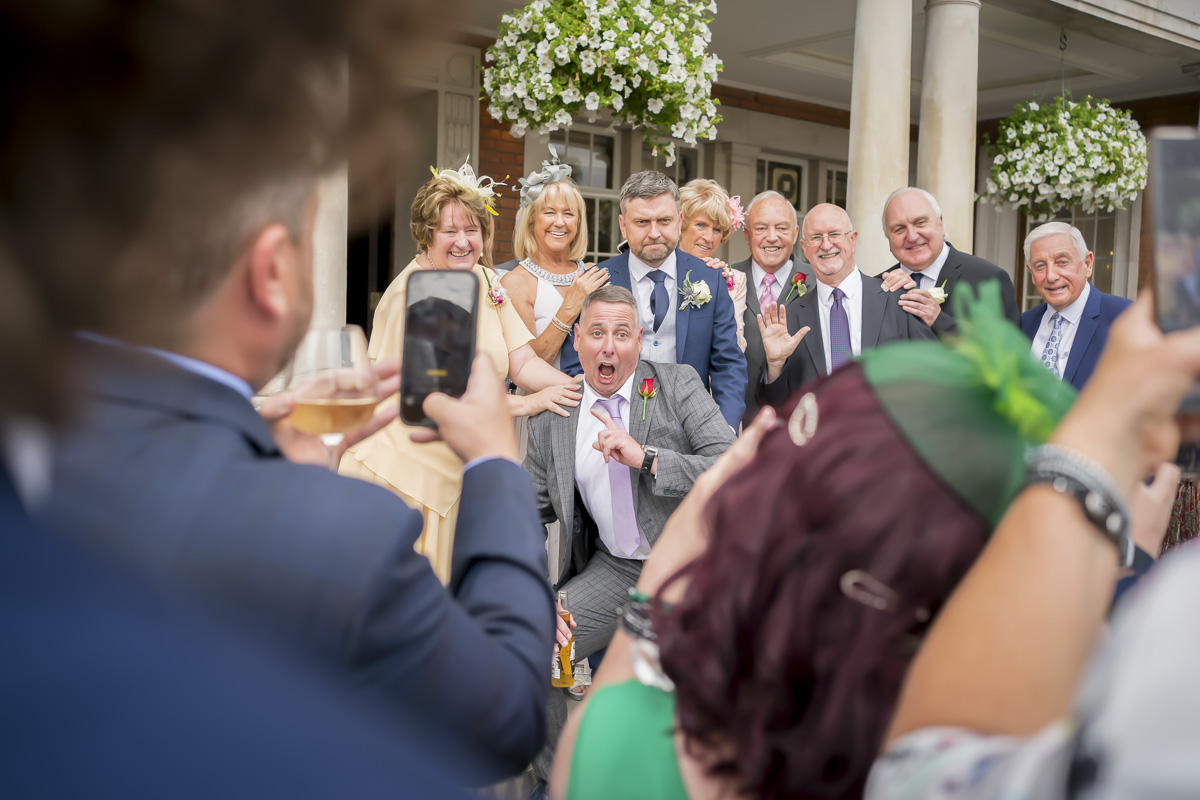 Group posing for a joyful wedding photo.