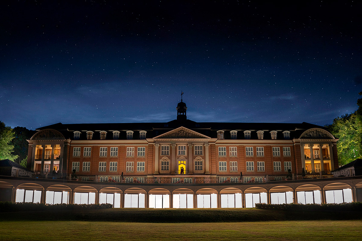 Illuminated historic building under starry night sky