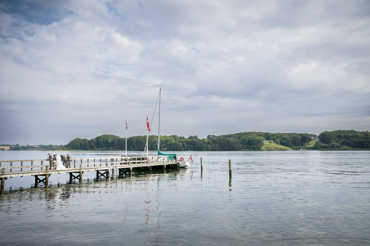 Wooden pier with sailboat on calm lake