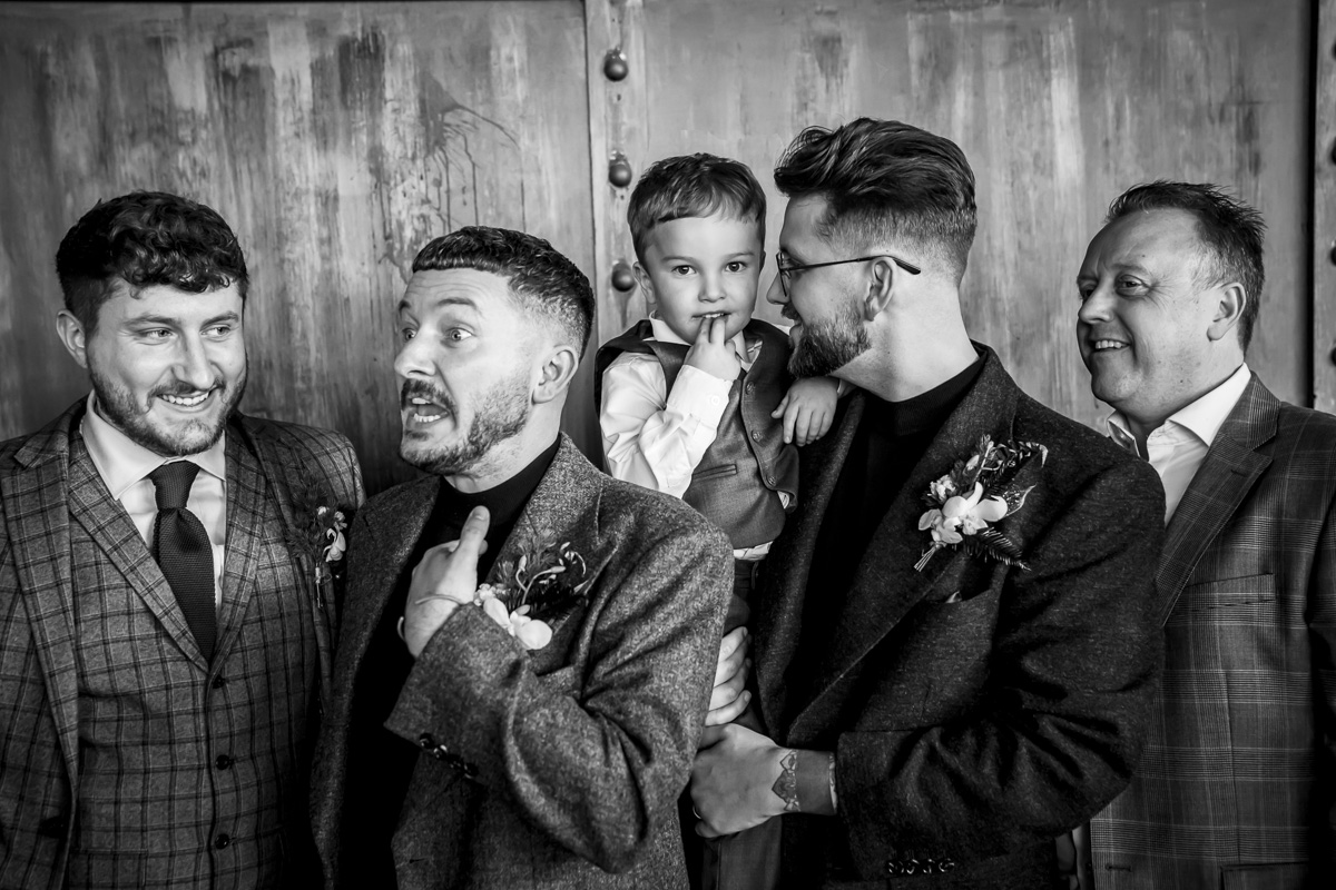 Group of men with child smiling and talking.